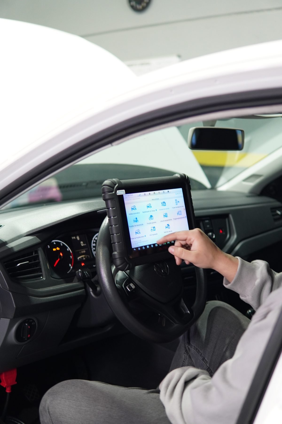 Scanner automotivo conectado ao painel de um veículo para diagnóstico eletrônico